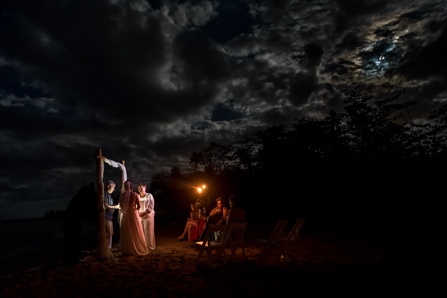 Couple standing during their beach wedding ceremony under the full moon in Rincon Puerto Rico